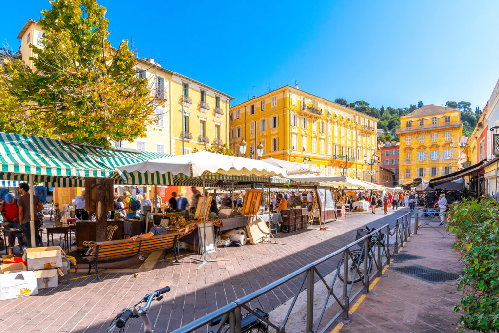 Open-air market on the Cours Saleya in Nice with colourful stalls and ochre facades