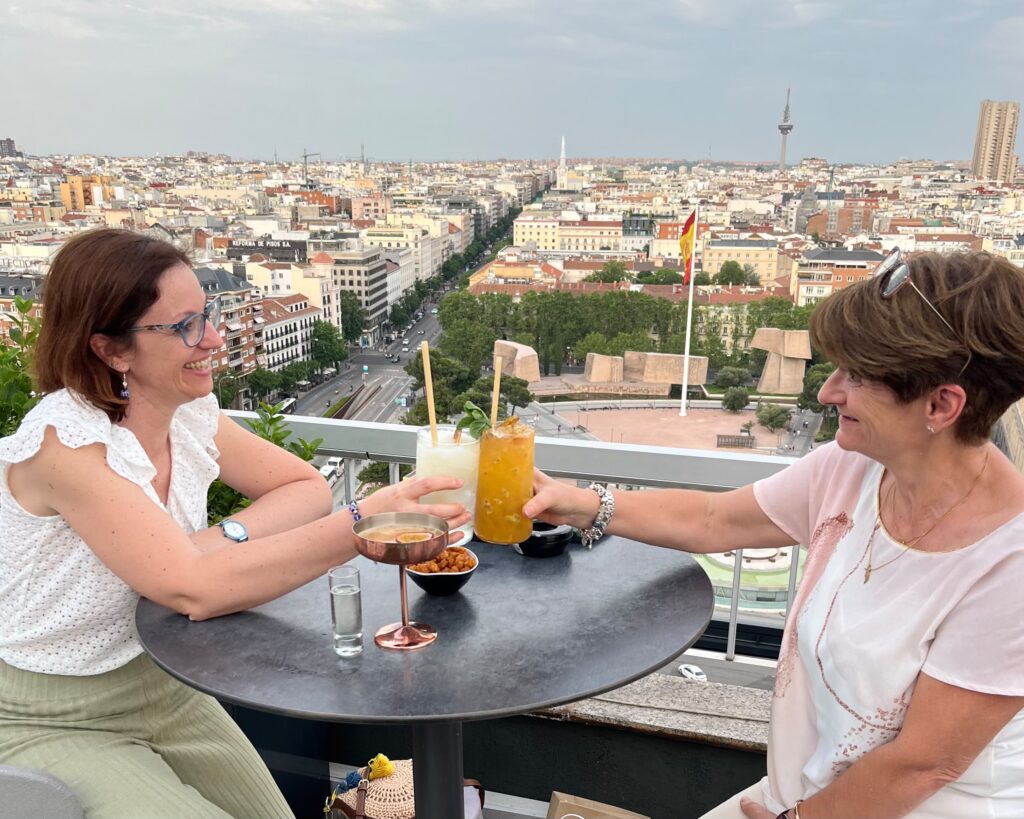 Trilingual French teacher enjoying a drink on a Madrid rooftop, a nod to her years living in Spain