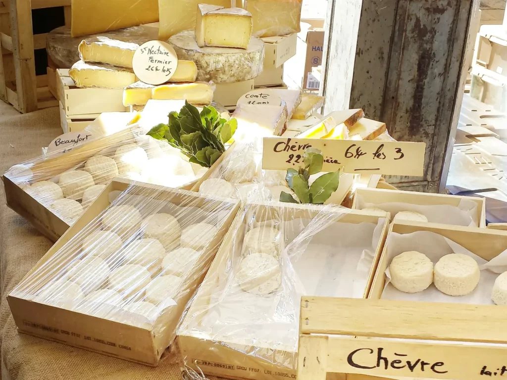 Cheese stall with handwritten price signs at a market in Aix-en-Provence